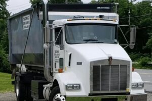 full dumpster with job crew in background